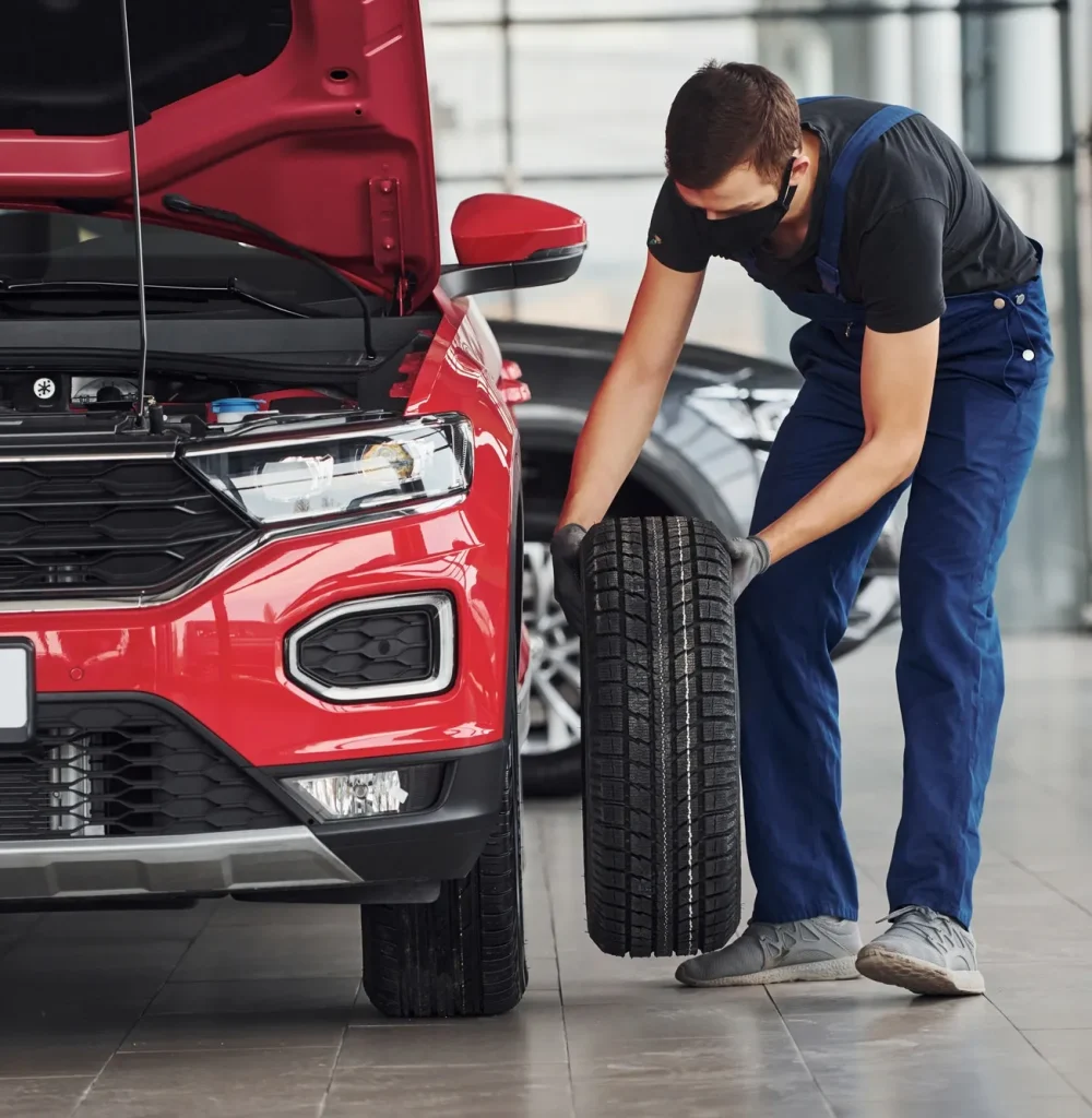 man-in-uniform-changing-tire-of-automobile-conception-of-car-service.jpg